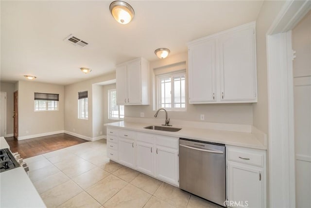 kitchen with a sink, light countertops, white cabinetry, stainless steel dishwasher, and visible vents