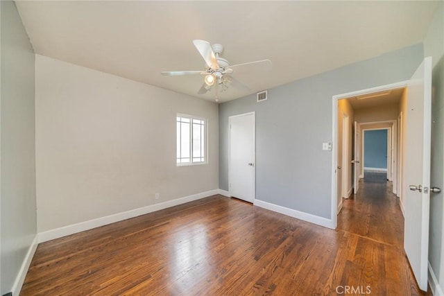 unfurnished bedroom featuring baseboards, wood finished floors, and visible vents