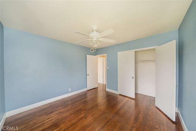 unfurnished bedroom with baseboards, ceiling fan, wood finished floors, and a closet