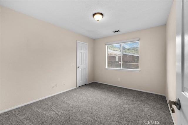 carpeted spare room with baseboards and visible vents