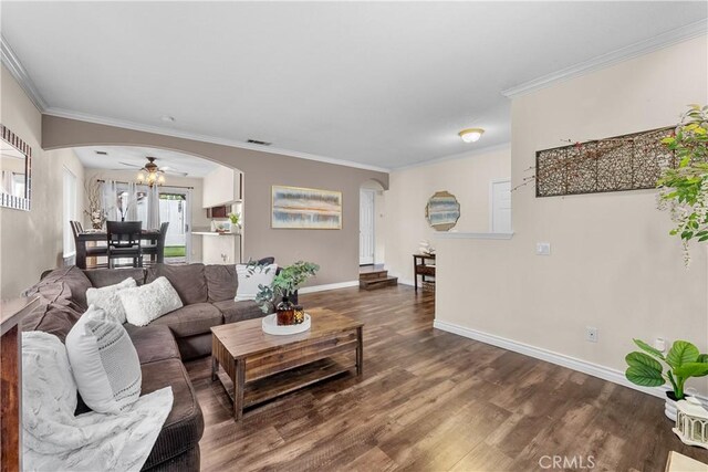 living room with arched walkways, ceiling fan, ornamental molding, and dark wood-type flooring