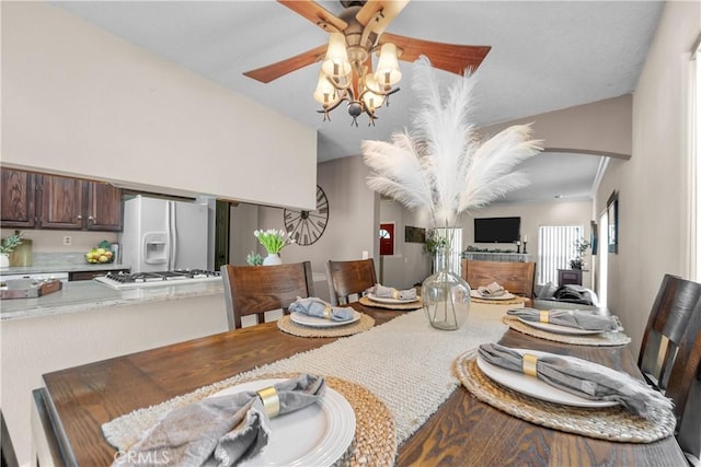 dining space with arched walkways and a ceiling fan