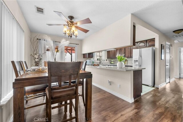 dining space with baseboards, ceiling fan, light wood-type flooring, and visible vents