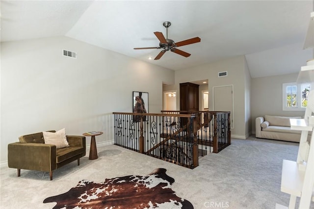 sitting room featuring visible vents, carpet floors, lofted ceiling, and an upstairs landing