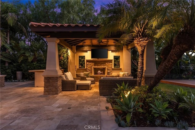 view of patio / terrace featuring a gazebo and an outdoor living space with a fireplace