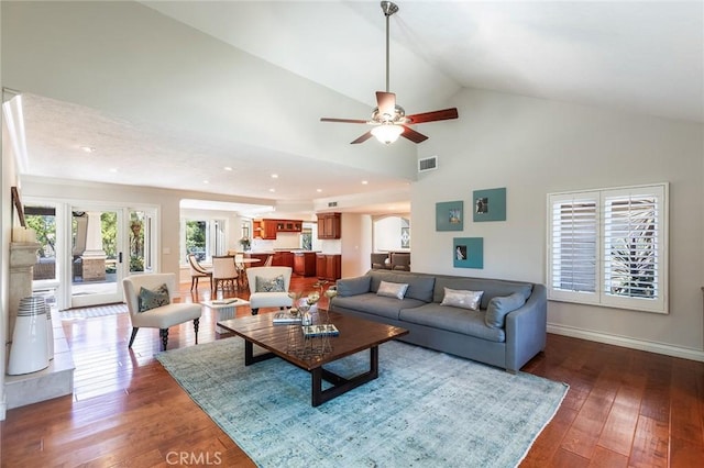 living area with a ceiling fan, visible vents, baseboards, high vaulted ceiling, and hardwood / wood-style floors