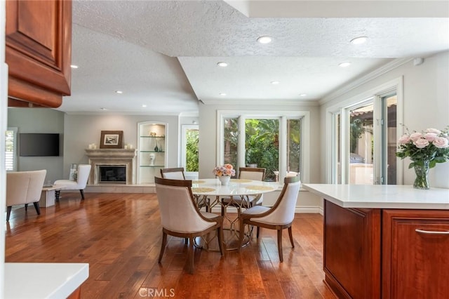 dining room featuring a textured ceiling, a glass covered fireplace, and hardwood / wood-style floors