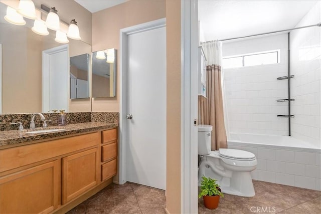 bathroom with vanity, tile patterned flooring, toilet, and tiled shower / bath