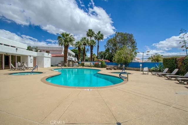 community pool featuring a patio, fence, and a community hot tub