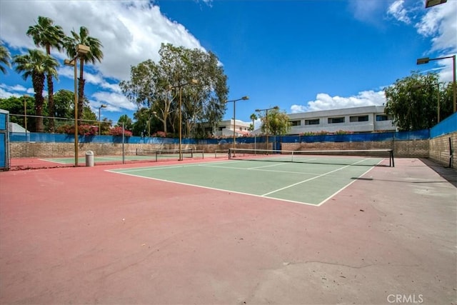 view of tennis court with fence and community basketball court