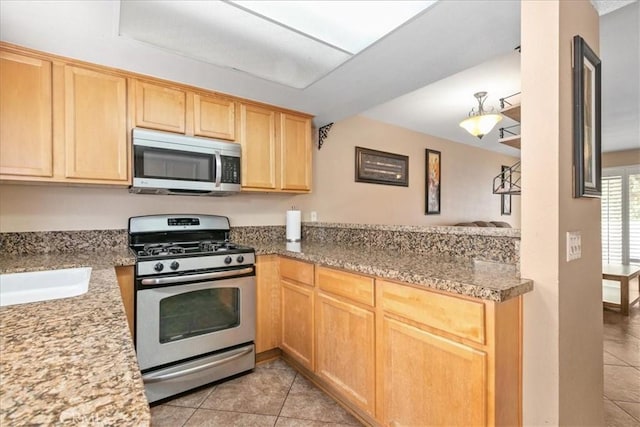 kitchen featuring a sink, appliances with stainless steel finishes, light tile patterned floors, and light brown cabinets