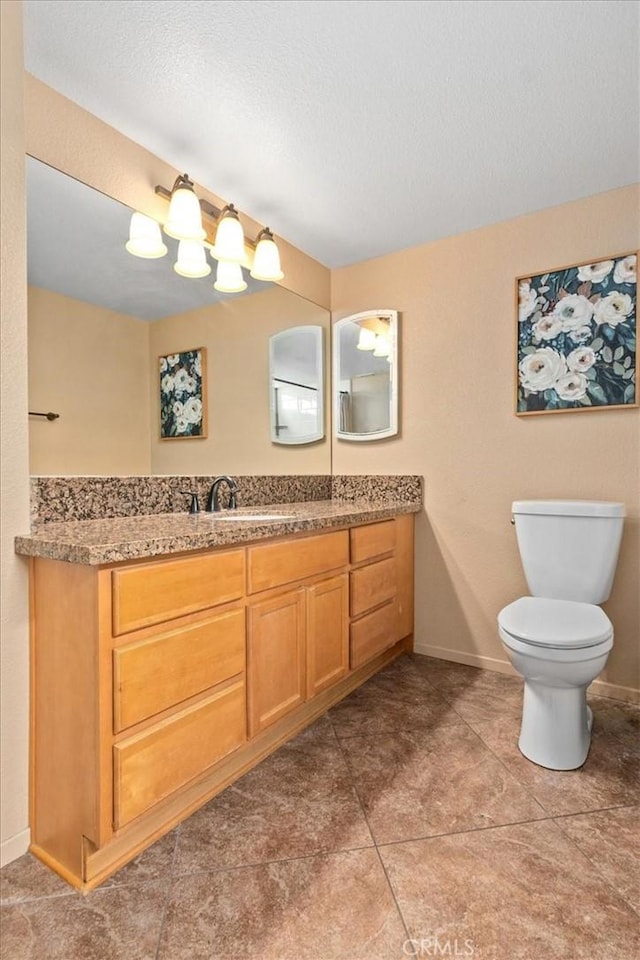 bathroom featuring toilet, baseboards, tile patterned flooring, and vanity