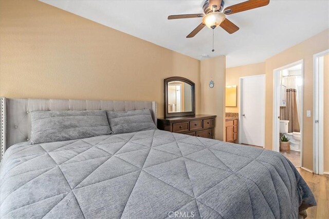 bedroom with ensuite bathroom, ceiling fan, and wood finished floors
