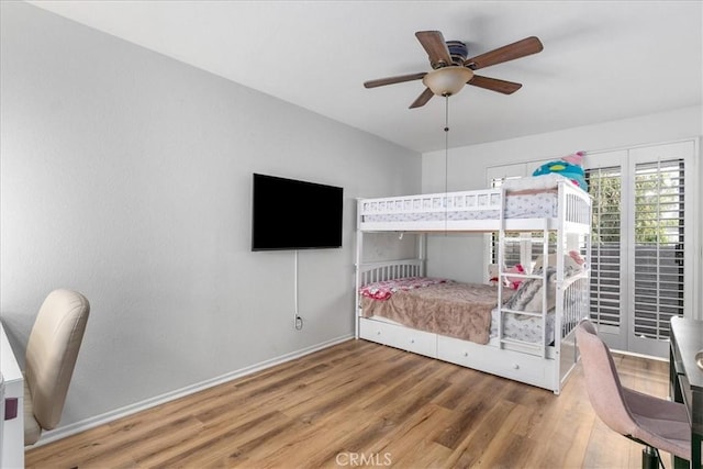 bedroom featuring baseboards, ceiling fan, and wood finished floors