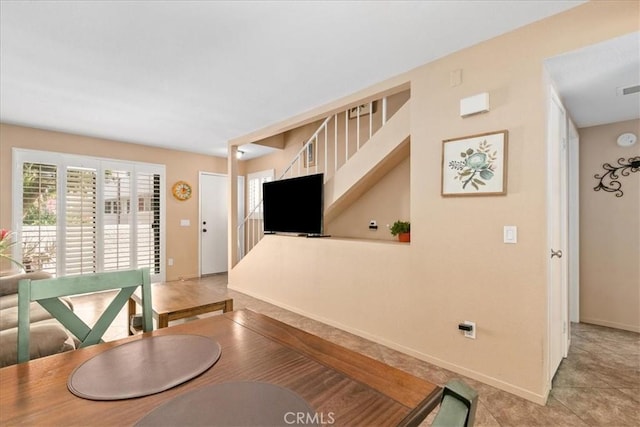 dining area with stairway, baseboards, and light tile patterned floors
