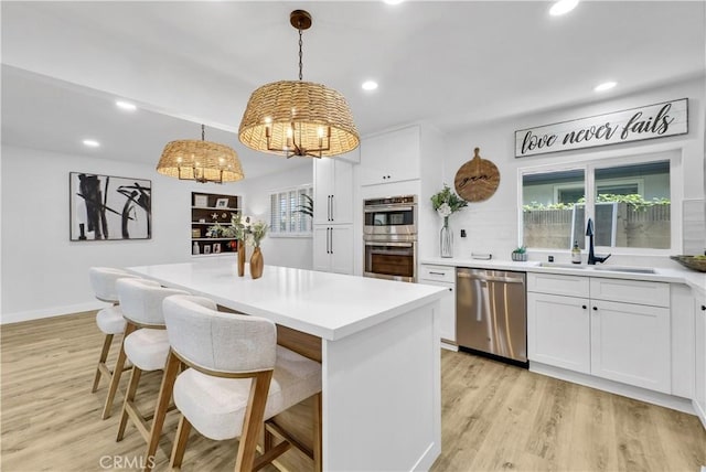 1467 N Kathleen Ln, Orange, CA 92867 - kitchen with a sink, appliances with stainless steel finishes, light wood finished floors, and white cabinetry