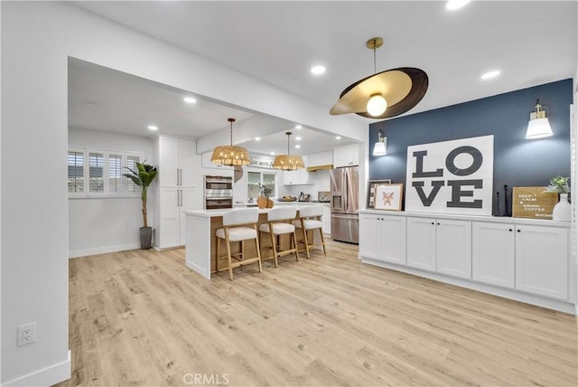 1467 N Kathleen Ln, Orange, CA 92867 - kitchen featuring light wood-type flooring, a kitchen island, white cabinets, and stainless steel appliances