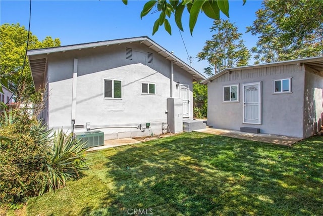 636 Harding Dr, Redlands, CA 92373 - back of property featuring a lawn, central AC unit, and stucco siding