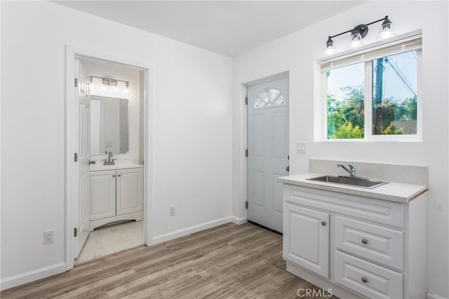 636 Harding Dr, Redlands, CA 92373 - bathroom featuring baseboards, a sink, two vanities, and wood finished floors