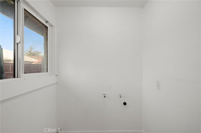 clothes washing area with laundry area, baseboards, and hookup for an electric dryer