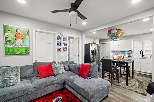 living area featuring recessed lighting, a ceiling fan, and light wood finished floors