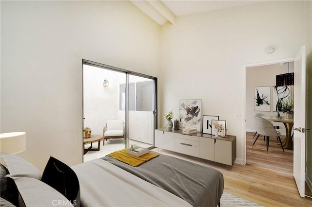 bedroom featuring light wood finished floors, high vaulted ceiling, and beamed ceiling