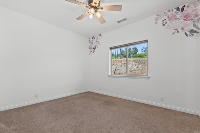 empty room with carpet flooring, a ceiling fan, baseboards, and visible vents