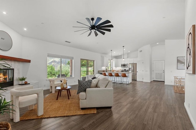 living area with recessed lighting, a ceiling fan, dark wood finished floors, and lofted ceiling
