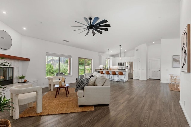 living area featuring recessed lighting, a ceiling fan, vaulted ceiling, and dark wood-type flooring