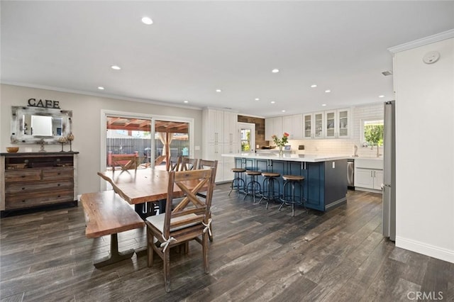 dining space featuring dark wood finished floors, baseboards, ornamental molding, and recessed lighting