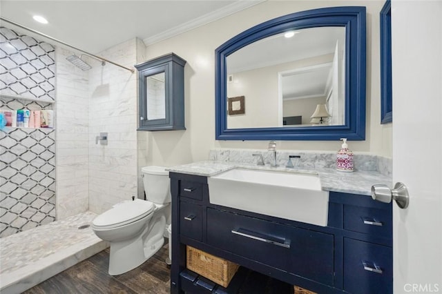 full bath featuring crown molding, toilet, tiled shower, and wood finished floors