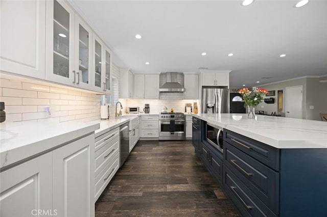 kitchen with recessed lighting, wall chimney exhaust hood, white cabinetry, tasteful backsplash, and stainless steel appliances