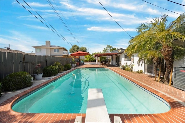 view of pool with a diving board, central air condition unit, a fenced in pool, a fenced backyard, and a patio