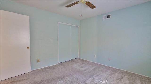 unfurnished room with carpet floors, a ceiling fan, and visible vents