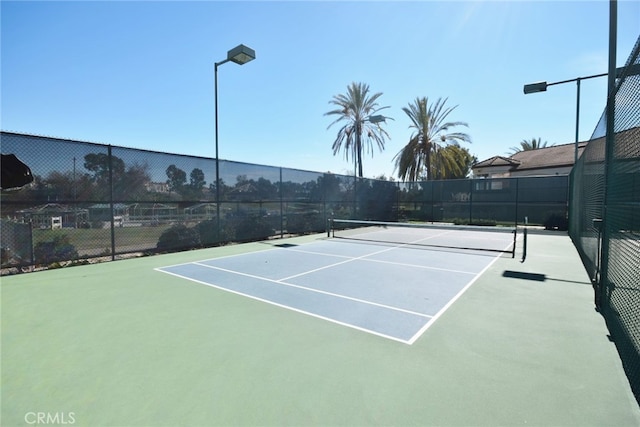 view of tennis court with fence
