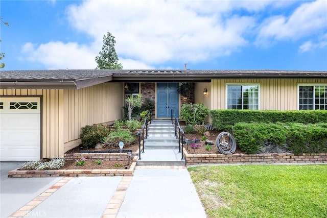 ranch-style home featuring a garage and a shingled roof