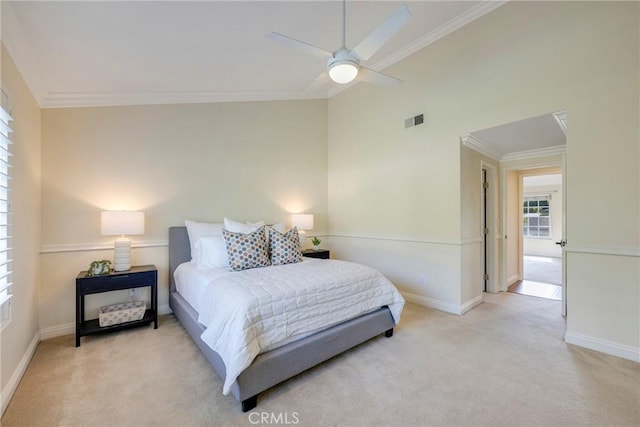 carpeted bedroom featuring visible vents, ornamental molding, baseboards, and a ceiling fan