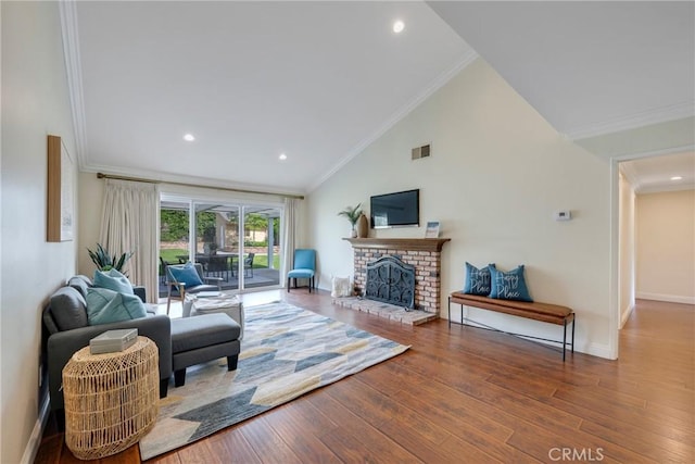 living area featuring a fireplace, vaulted ceiling, wood finished floors, baseboards, and ornamental molding