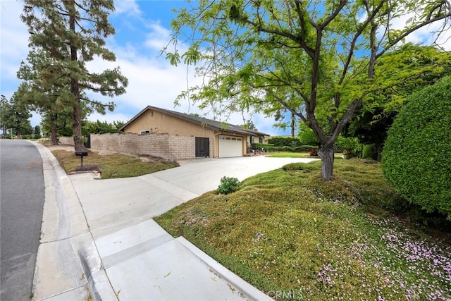 view of property exterior featuring a garage, stucco siding, and concrete driveway