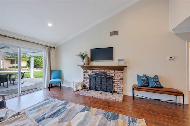living room featuring visible vents, ornamental molding, lofted ceiling, and wood finished floors