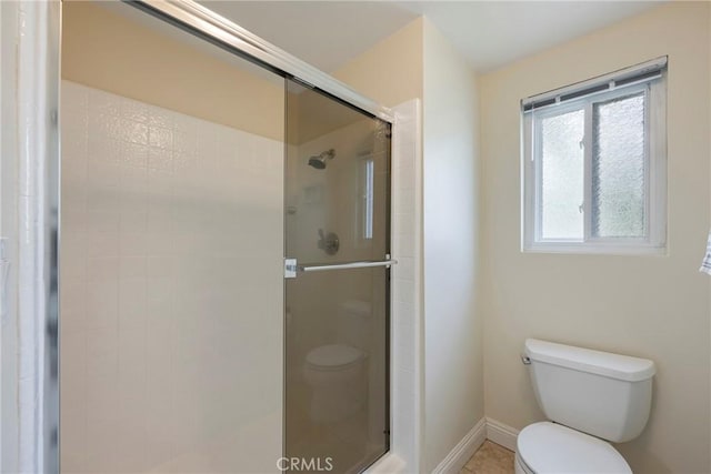 full bath with baseboards, tile patterned floors, toilet, and a shower stall