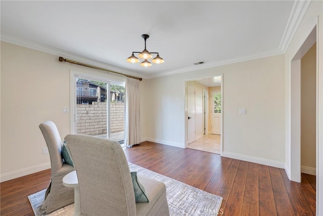 dining room featuring baseboards, ornamental molding, wood finished floors, and visible vents