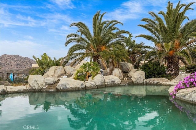 view of pool featuring fence and a mountain view
