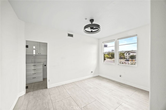 unfurnished bedroom with light tile patterned floors, baseboards, and visible vents