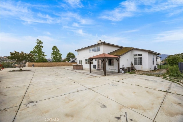 back of house featuring a gazebo, a patio area, stucco siding, and fence