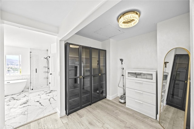 interior space with baseboards, a stall shower, and a soaking tub