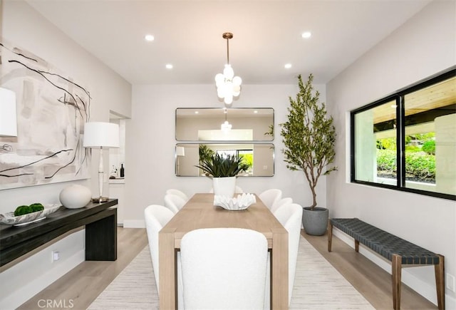 dining area featuring recessed lighting, baseboards, an inviting chandelier, and light wood-style flooring