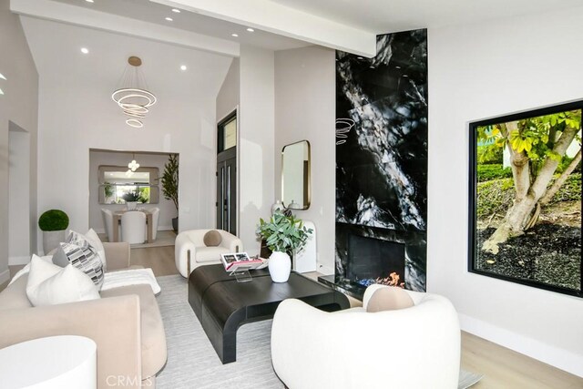 living area featuring recessed lighting, high vaulted ceiling, wood finished floors, and beam ceiling