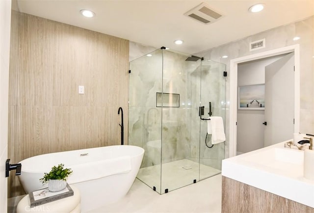 bathroom with visible vents, recessed lighting, a freestanding bath, and a shower stall