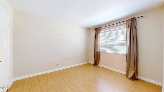 spare room with light wood-style floors and baseboards